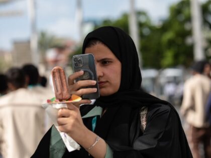 An attendee photographs an ice cream at a food court within the Green Zone on the opening