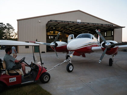 Max Maiden, 28, an aerial firefighting aircraft pilot, drives a cart to move the Beechcraf