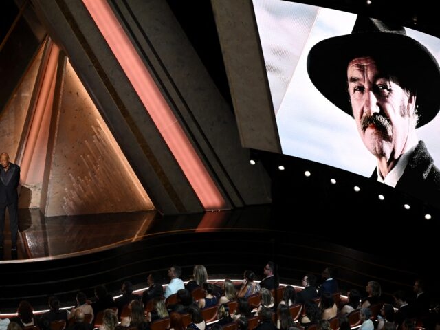 GettyImages-2202441787 (1) An image of late US actor Gene Hackman is seen on a screen as US actor Morgan Freeman stan