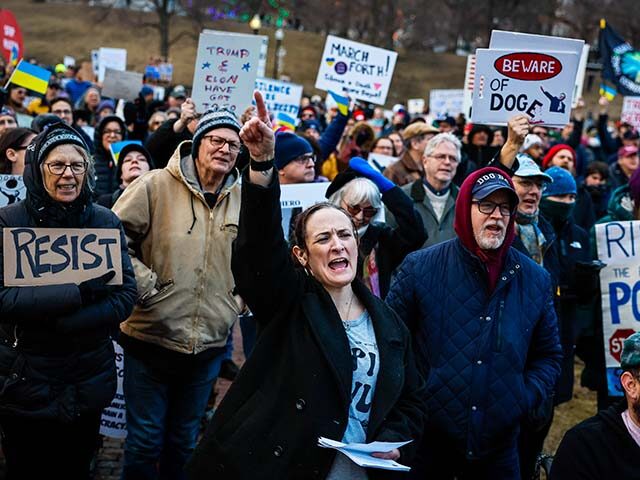 A woman chants with the crowd during the 50501 protest at Boston Common, surrounded by dem