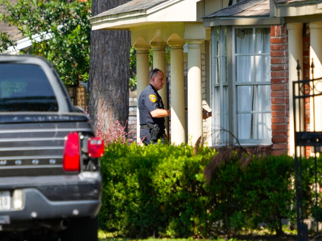 Police investigate the scene where a police officer was shot responding to an alleged home