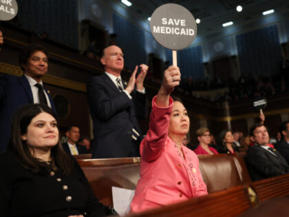 Rep. Jill Tokuda (D-HI) holds a protest sign with fellow Democrats as U.S. President Donal