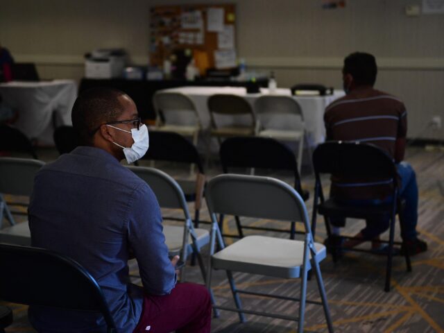 San Diego migrant shelter (Frederic J. Brown / AFP via Getty) People wait their turn in an intake and processing office at a migrant shelter run by Cath