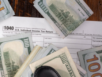 Individual tax return 1040 form payment concept with one hundred dollar bills. Tax day or