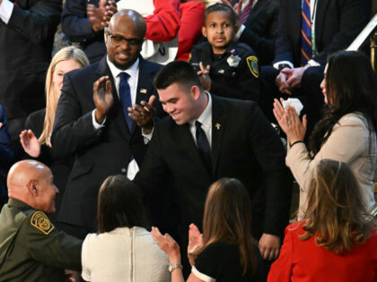 Jason Hartley (C) stands after US President Donald Trump announced that Hartley has been a