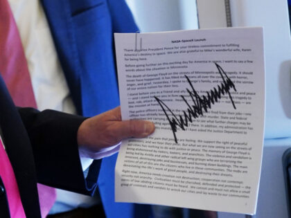 US President Donald Trump holds an autographed copy of his speech from the Kennedy Space C