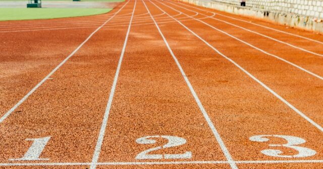 Track Runner Who Hit Opponent with Baton Holds Rally After Assault Charge