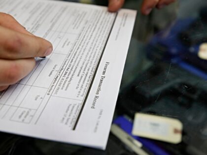 A customer fills out a background check form at Davidson Defense in Orem, Utah on February