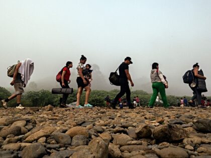 TOPSHOT - Migrants walk by the jungle near Bajo Chiquito village, the first border control