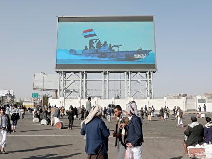 SANA'A, YEMEN - FEBRUARY 14: Yemen's Houthi supporters walk under a large screen broadcast