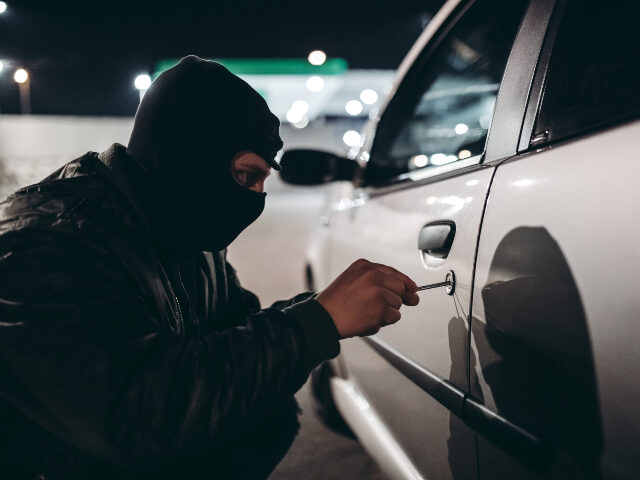 man breaking into car
