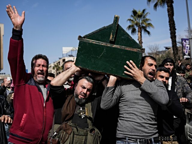 syria 09 March 2025, Syria, Hama: Syrian fighters and civilians carry the coffin of a member of