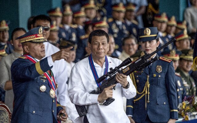 Former Philippine president Rodrigo Duterte, shown holding a rifle in 2018, faces charges