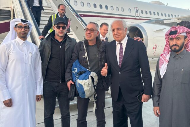 This photo released by Qatar's foreign ministry shows US citizen George Glezmann (C) with