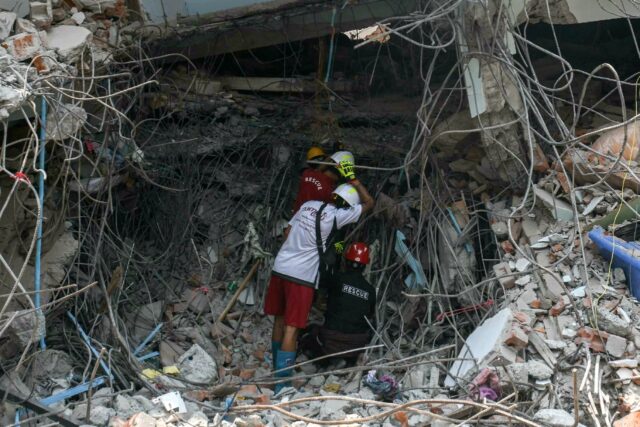 Rescuers search through the rubble of a quake-damaged building looking for survivors in Ma