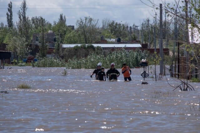 Rescuers wade through floodwaters following a heavy storm that hit the Argentinian port ci