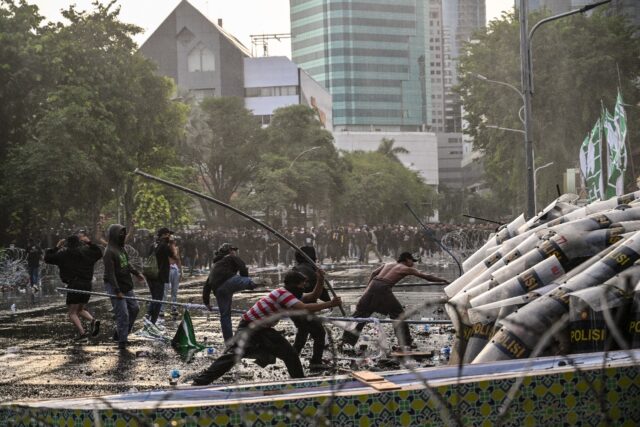 Students threw a stone at riot police during a protest against a revision to the armed for