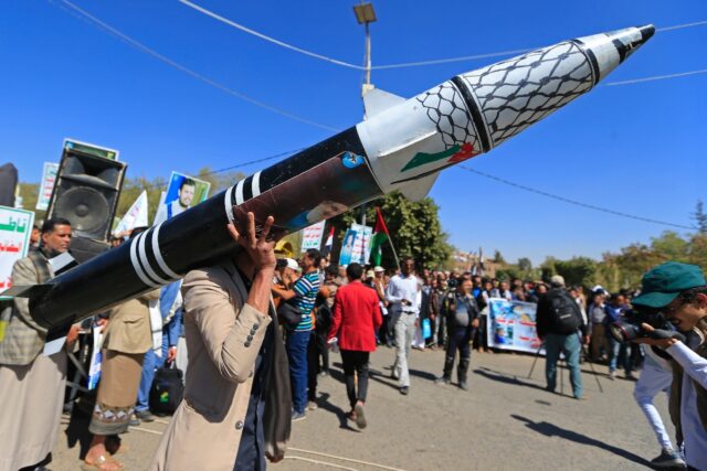 A Yemeni protester holds a mock rocket during an anti-Israel demonstration in the Huthi-co