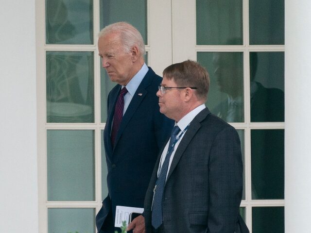 President Joe Biden walks along the Colonnade at the White House with his physician Kevin