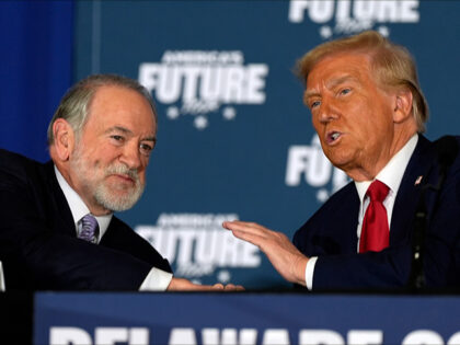 Republican presidential nominee former President Donald Trump talks with former Arkansas G
