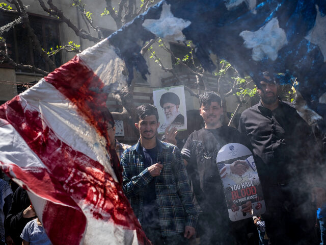 Afghan refugees are holding an anti-U.S. placard and a portrait of Iran's Supreme Lea