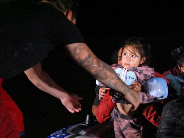 An immigrant child glances towards human trafficker while being smuggled into the United S