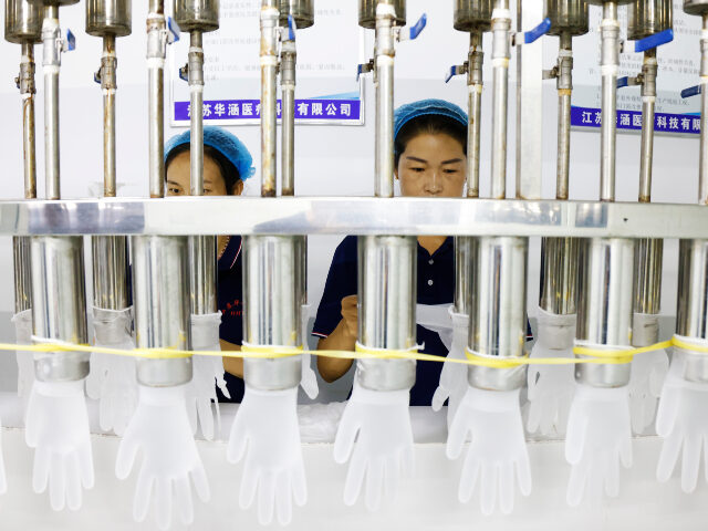 Workers make disposable PVC gloves for domestic and international markets at a production