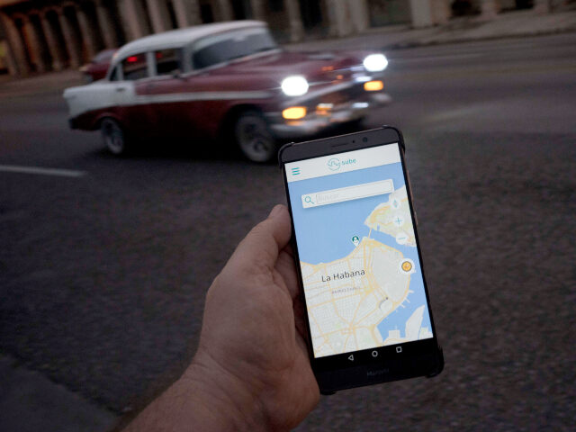 Cuba internet A man holds his phone showing the app "Sube," a ride-hailing app for the aging A