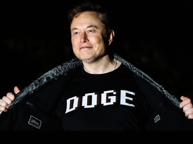 Elon Musk shows off his DOGE shirt on stage