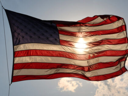 HOBOKEN, NJ - MAY 15: The sun sets behind an American Flag on May 14, 2020 in Hoboken, New