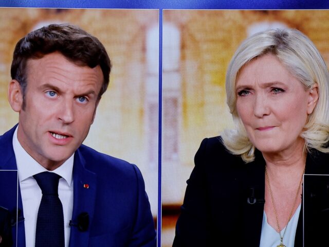 A picture shows screens displaying a live televised debate between French President and La