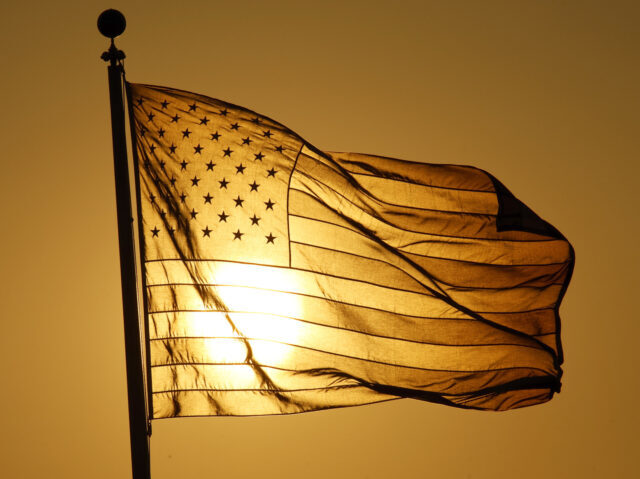 BAYONNE, NJ - JULY 21: The sun sets behind an American flag at the Tear Drop 9/11 Memorial