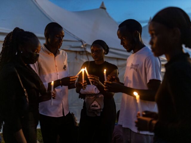 GettyImages-2147061391 People light candles during a night vigil at Nyanza Genocide Memorial Center as part of th