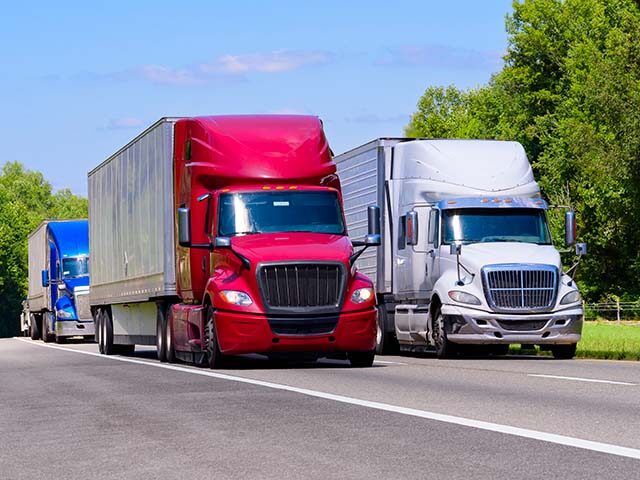 Red, White, and Blue Trucks On Interstate