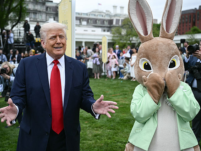 US President Donald Trump speaks as he stands next to an constumed Easter bunny during the