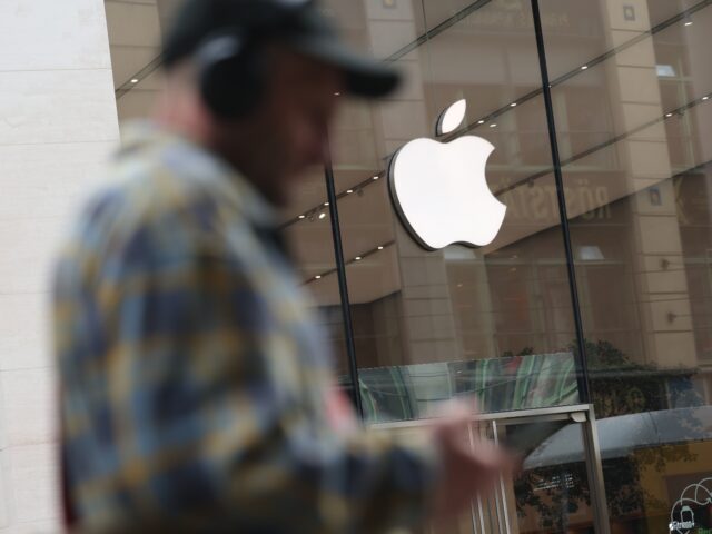 BERLIN, GERMANY - APRIL 23: A man with headphones and carrying a smartphone walks past an