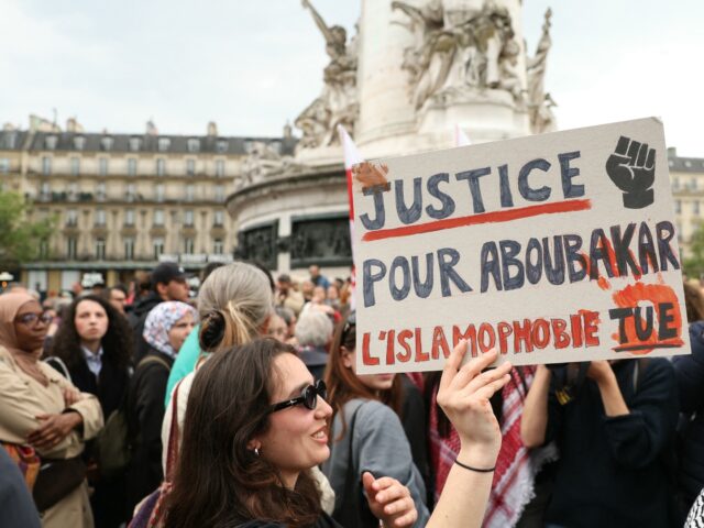 A protestor holds a sign reading 