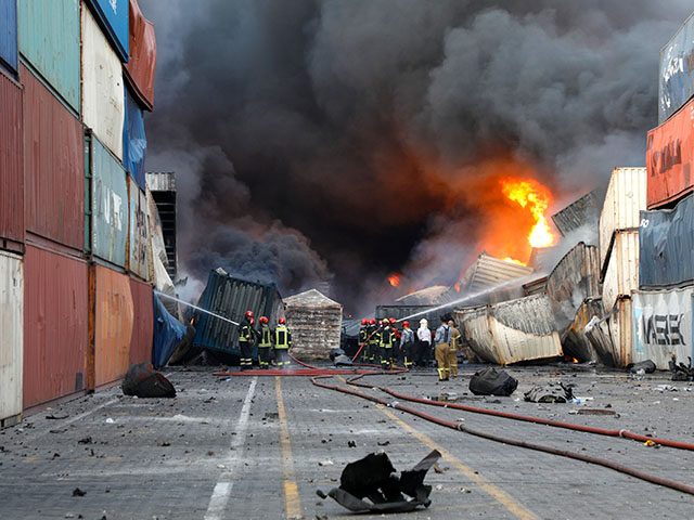 Firefighters at the scene of an explosion that took place a day earlier at the Shahid Raja