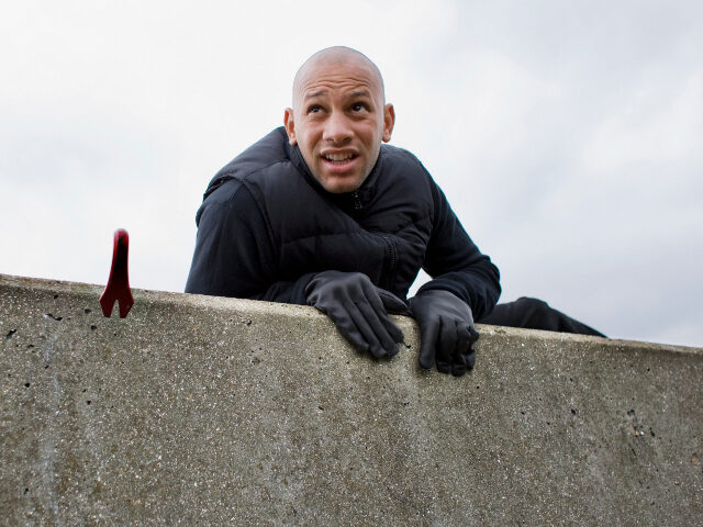 Intruder climbing over wall