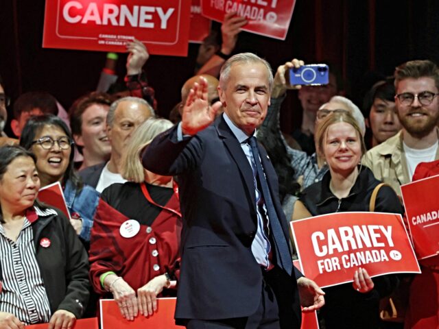 Canada's Prime Minister and Liberal Party leader Mark Carney waves to supporters at a vict