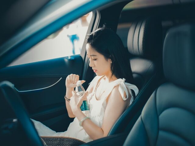 Woman Drinking Water Inside a Luxury Car