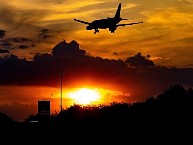Silhouette of an airplane landing, on final approach during the sunset at London Heathrow