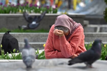 An elderly woman at a makeshift memorial for fallen Ukrainian and foreign fighters in Kyiv