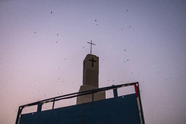 Bats fly over a church tower in Jos, capital of the religiously mixed Plateau state, Niger