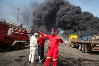 Black smoke rises as rescuers arrive near the scene of a deadly explosion at the Shahid Ra