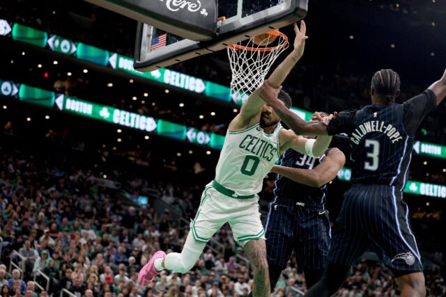 Boston Celtics forward Jayson Tatum is fouled on a dunk attempt by Orlando's Kentavious Ca
