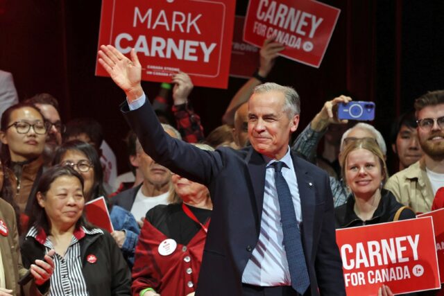 Canada's Prime Minister and Liberal Party leader Mark Carney waves to supporters at a vict