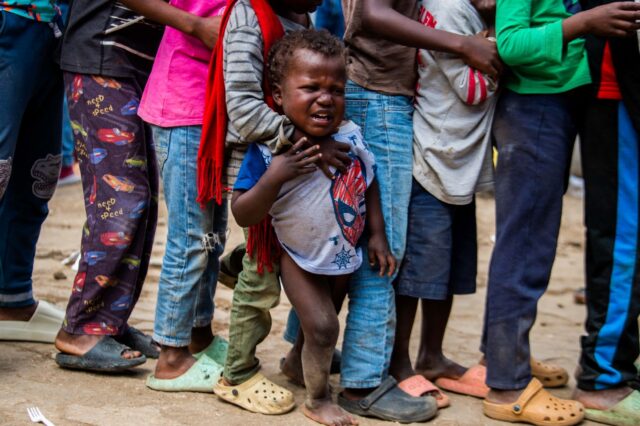 Children wait for food at a shelter for families displaced by gang violence in Port-au-Pri