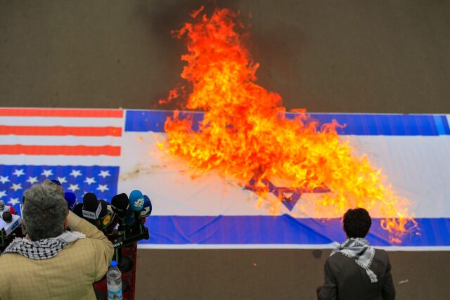 Demonstrators burn US and Israeli flags during a Sanaa rally in solidarity with Palestinia