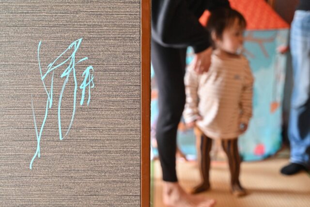 A drawing (L) on the side of a sliding screen door at the home of 21-month-old artist "Thu